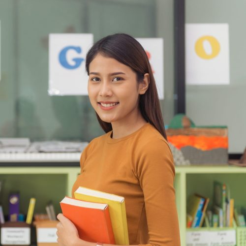 pretty-asian-teacher-smiling-camera-back-classroom-elementary-school-vintage-effect-style-pictures-1-scaled-e1713753891927.jpg